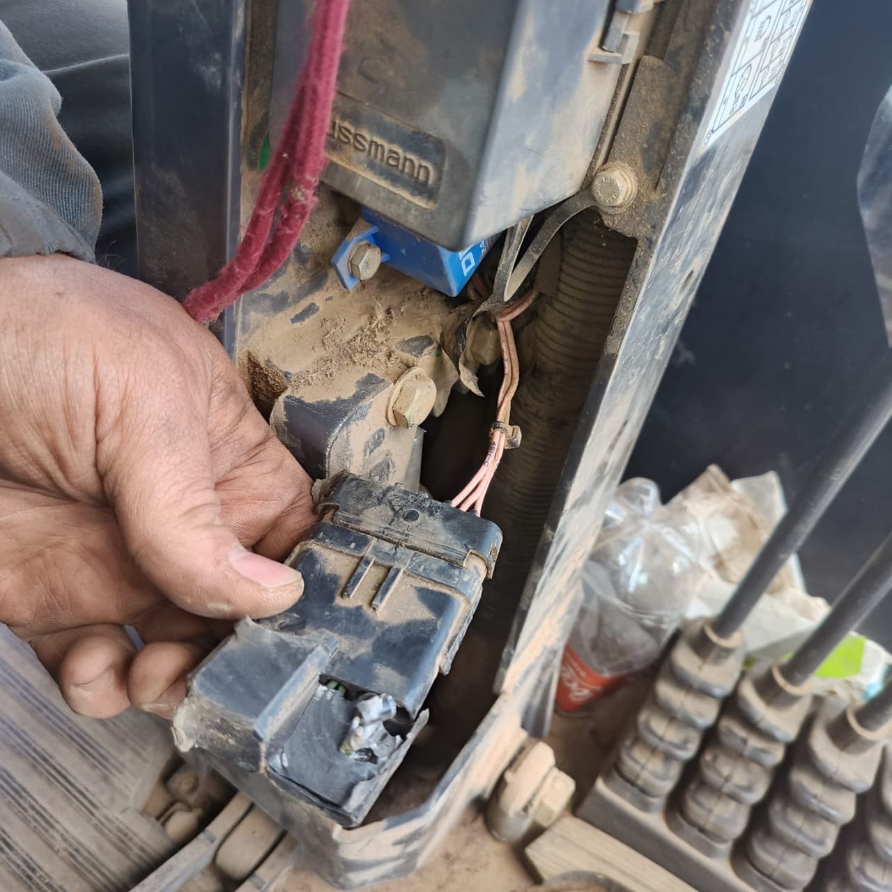 Técnico segurando um conector elétrico desconectado