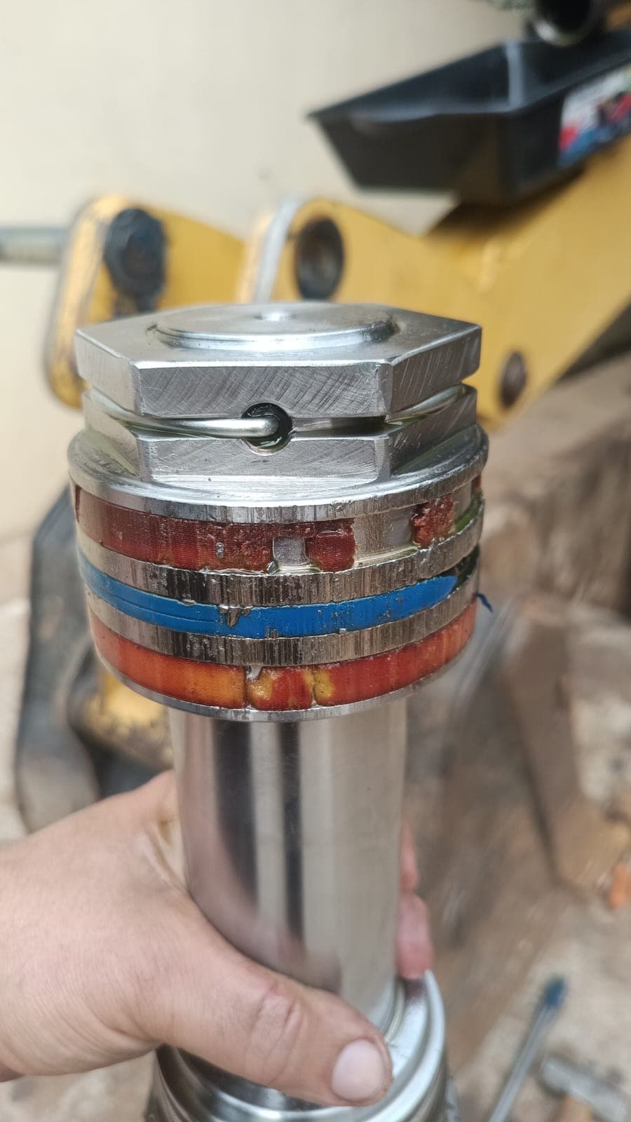 Conjunto do pistão de um cilindro hidráulico, com os anéis de vedação, segurado pelo técnico